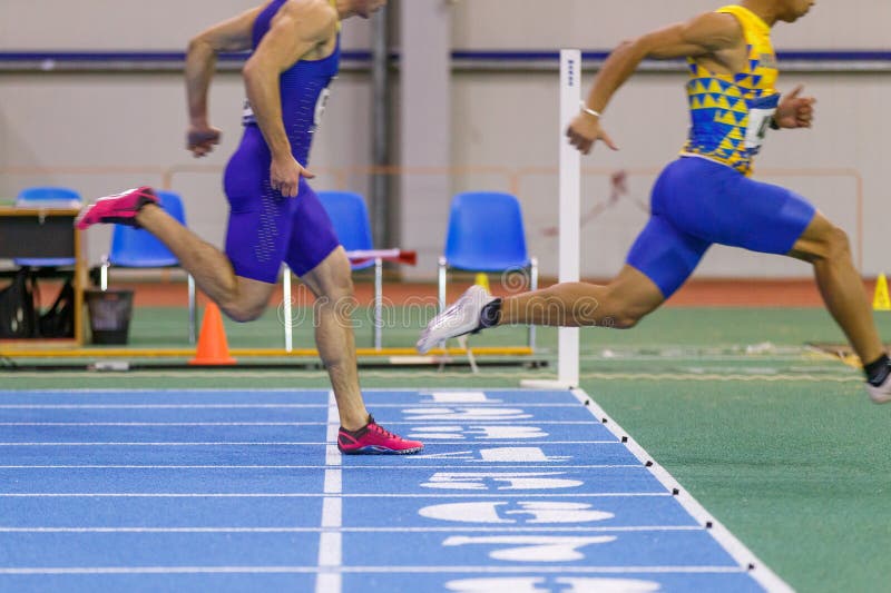 Спортсмены бежать вне финишная черта в спринте стоковая фотография
